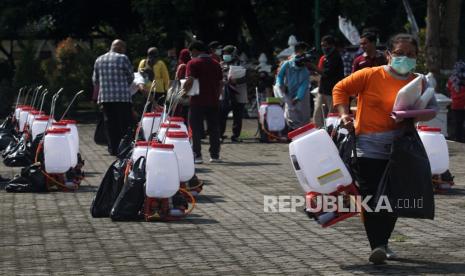 Petugas membawa alat penyemprot disinfektan di Lapangan Pemda Sleman, D.I Yogyakarta, Jumat (27/3/2020)