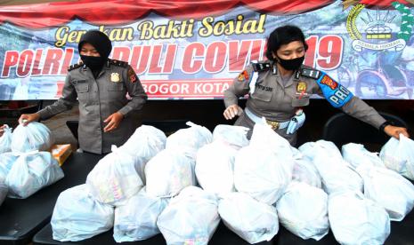 Anggota Polwan menyiapkan paket sembako