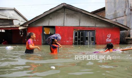 Sejumlah pelajar melintasi banjir rob di Medan Utara, Medan, Sumatera Utara, Rabu (8/5/2024). Badan Meteorologi Klimatologi dan Geofisika (BMKG) Stasiun Meteorologi Kelas II Maritim Belawan memperkirakan banjir rob yang melanda daerah tersebut akan berlangsung hingga 11 Mei 2024 dengan tinggi air mencapai 2,7 meter.