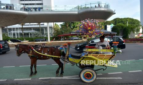 Kusir menunggu calon penumpang delman di kawasan Bundaran HI, Jakarta Pusat, Ahad (1/1/2023). 