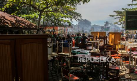 Warga membantu mengeluarkan barang-barang dari dalam ruangan ketika petugas Pemadam Kebakaran Kota Pekanbaru melakukan pendinginan di puing-puing bangunan yang hangus terbakar di SD Negeri 118 Pekanbaru, Riau, Jumat (15/10/2021). Sedikitnya tujuh ruangan belajar dan satu rumah penjaga sekolah hangus terbakar dalam peristiwa tersebut. 