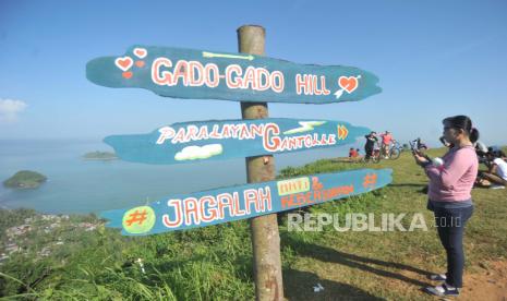 Pemkot Padang Godok Lima Destinasi Baru Geliatkan Pariwisata. Warga menikmati panorama dari puncak Bukit Gado-gado, di Padang, Sumatera Barat, Minggu (28/6/2020). Puncak bukit Gado-gado yang biasa dijadikan arena aerosport tersebut berpotensi untuk dikembangkan menjadi objek wisata dengan panorama pantai Air Manis, Teluk Bayur dan Samudera Hindia. ANTARA FOTO/Iggoy el Fitra/foc.