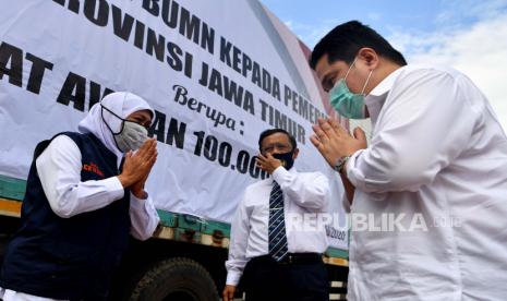 Menko Polhukam Mahfud MD (tengah) bersama  Menteri BUMN Erick Thohir (kanan) dan Gubernur Jawa Timur Khofifah Indar Parawansa (kiri) saling berbincang di depan kontainer yang berisi bantuan obat-obatan di halaman Gedung Negara Grahadi, Surabaya, Jawa Timur, Minggu (5/7/2020). Kunjungan tersebut dalam rangka menyerahkan bantuan penanganan COVID-19 di Jawa Timur dan diskusi bersama Forum Komunikasi Umat Beragama (FKUB) terkait Rencana Undang-undang (RUU) Haluan Ideologi Pancasila (HIP). ANTARA FOTO/Zabur Karuru/foc.