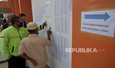 Sejumlah warga mencari nama mereka di daftar penerima Bantuan Sosial Tunai (BST) di Kantor Pos Pekanbaru, Riau, Selasa (12/5/2020).  Kementerian Sosial meminta upaya nyata dari pemerintah daerah untuk secepatnya melengkapi data penerima BST karena dari target 9 juta kepala keluarga (KK), Kementerian Sosial baru menerima sekitar 7,8 juta KK