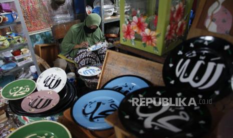 Perajin menyelesaikan lukisan kaligrafi Arab pada piring keramik di Fairus Art, Pasar Kliwon, Jawa Tengah, Kamis (8/4/2021). Kerajinan piring lukis kaligrafi Arab yang dijual seharga Rp100.000 per pasang tersebut banyak diminati pembeli karena bantuan promosi lewat pameran produk UMKM digital dan dipasarkan secara daring dengan media sosial. 