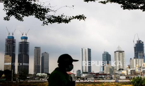 Warga melintas dengan latar belakang gedung bertingkat di Jakarta. Ada lima kunci transformasi yang digenjot pemerintah untuk bisa mengeluarkan Indonesia dari middle income trap.