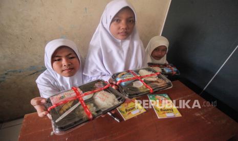 Sejumlah siswa menunjukan paket makanan saat uji coba makan bergizi gratis di SDN Sentul 03, Kabupaten Bogor, Jawa Barat, Selasa (23/7/2024). Menu makanan saat uji coba itu adalah paket nasi, ayam goreng, sayur, buah dan susu. Uji coba program makan bergizi gratis dilakukan hingga Oktober 2024, dan akan  mencoba berbagai skema diantaranya  memanfaatkan UMKM, warung kecil, warteg, ataupun katering kecil. 