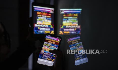 Warga melihat iklan judi online melalui gawainya