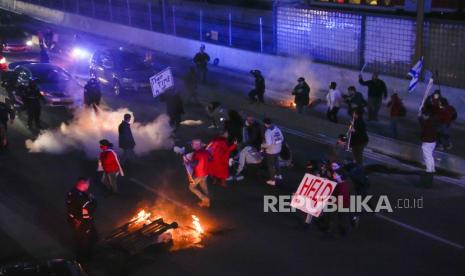 People block a highway during a protest demanding the release of the hostages taken by Hamas militants into the Gaza Strip during the Oct. 7th attack, in Tel Aviv, Israel, Saturday, Feb. 10, 2024. 