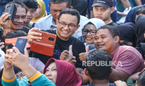 Anies Baswedan (kiri) berswafoto dengan warga saat car free day, di Jalan Jenderal Sudirman, Jakarta, Ahad (4/8/2024). Pendukung Anies kini menyuarakan gerakan coblos tiga paslon.