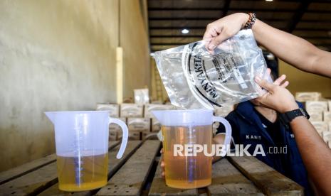 Kasatreskrim Polresta Samarinda AKP Dicky Anggi Pranata (kanan) menuangkan Minyakita kemasan pouch ke dalam gelas ukur saat melakukan sidak terhadap ketersediaan bahan pokok penting (bapokting) di gudang distributor Minyakita di Samarinda, Kalimantan Timur, Selasa (11/3/2025). Satgas pangan Polresta Samarinda melakukan sidak ke gudang distributor dan pengecer sebagai tanggapan terhadap keresahan masyarakat terkait dugaan perbedaan isi minyak goreng dengan label yang tertera pada kemasan. 