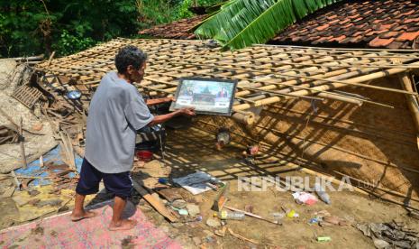 Warga mengambil bingkai foto dekat rumah yang roboh akibat diterjang angin puting beliung di Desa Kalirejo, Undaan, Kudus, Jawa Tengah, Jumat (22/10/2021). Bencana angin puting beliung yang menerjang empat desa di kabupaten itu pada Kamis (21/10/21) sore tersebut mengakibatkan 106 rumah rusak berat hingga ringan dan puluhan pohon tumbang, serta memutus aliran listrik.