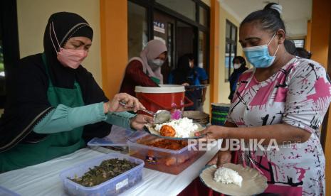 Warga antre untuk mendapatkan makanan gratis di Warung Ikhlas di Gedung Sasana Krida Karang Taruna (SKKT) di Pademangan Timur, Jakarta, Jumat (22/10). Pada tahap awal Warung Ikhlas Pademangan Timur menyediakan makan gratis sebanyak 100 porsi per hari sebagai bentuk kepedulian terhadap warga di masa pandemi. Warung Warung Ikhlas Pademangan Timur tersebut diinisiasi oleh Pengajian/Majelis Ridho Allah bekerja sama dengan pemerintah kota Jakarta Utara.  