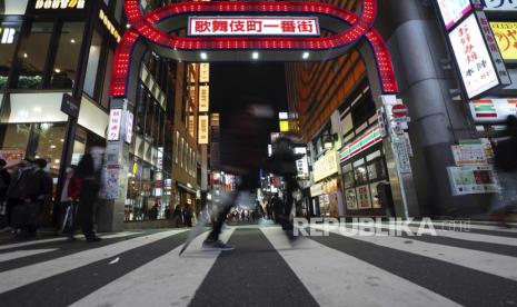  Seorang pria yang mengenakan masker pelindung untuk membantu mengekang penyebaran virus korona berjalan di depan sebuah jalan bar yang populer Rabu, 25 November 2020, di Tokyo.