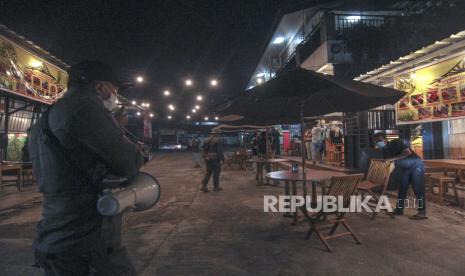 Petugas gabungan memberikan imbaun agar segera menutup toko saat operasi pembatasan jam operasional di Sawangan, Depok, Jawa Barat, Selasa (22/6/2021). Pemerintah Kota Depok memberlakukan pembatasan jam operasional terhadap pusat perbelanjaan, restoran, dan pertokoan hingga pukul 19.00 WIB dan aktivitas warga hingga pukul 21.00 WIB guna mencegah penyebaran COVID-19.