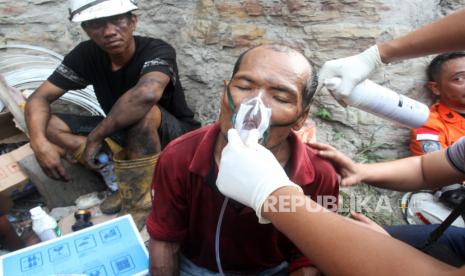 Tim kesehatan memberikan oksigen pada relawan yang mencari korban di bekas ledakan pada lokasi tambang batu bara di Kecamatan Talawi, Kabupaten Sawahlunto, Sumatera Barat, Jumat (9/12/2022). Basarnas Padang menyebutkan ledakan tambang batu bara yang dipicu oleh gas metana mengakibatkan 10 pekerja meninggal dunia dan empat pekerja mengalami luka bakar serius. 