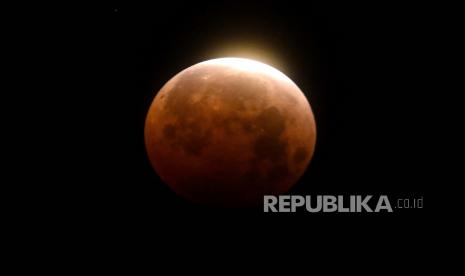 Cahaya bersinar dari gerhana bulan total di atas Pantai Santa Monica di Santa Monica, California, Rabu, 26 Mei 2021. 