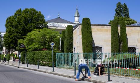  Seorang anggota staf Masjid memasang tanda untuk jarak sosial di lantai di depan Masjid Jenewa, juga dikenal sebagai Masjid Petit-Saconnex, untuk sholat pertama setelah pembukaan kembali Masjid di Jenewa, Swiss, 01 Juni 2020. Tapak Sejarah Islam di Swiss