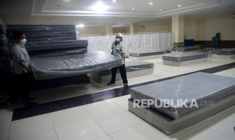 Petugas menata tempat tidur di Gelanggang Olahraga (GOR) Kecamatan Tanjung Priok, Jakarta, Selasa (8/2/2022). Pemerintah Kota Jakarta Utara menyiapkan GOR Tanjung Priok sebagai lokasi isolasi terkendali untuk penanganan pasien COVID-19 yang memiliki kapasitas maksimal mencapai 400 orang.Prayogi/Republika.