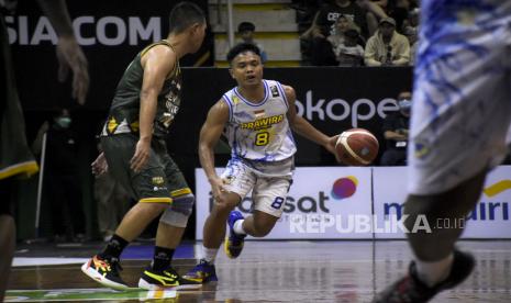 Pebasket Prawira Bandung Yudha Saputera (kanan) berusaha melewati hadangan pebasket Dewa United Surabaya saat pertandingan Playoff IBL Tokopedia 2022 di Gor C-Tra Arena Bandung, Kota Bandung, Sabtu (13/8/2022). Dalam pertandingan tersebut, Prawira Bandung berhasil mengalahkan Dewa United Surabaya dengan skor 78-74. Republika/Abdan Syakura