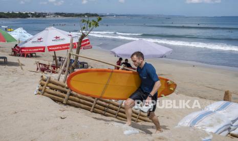  Wisatawan mancanagera (wisman) berjalan-jalan di pantai Kuta, Bali. Pemerintah Provinsi Bali memastikan keamanan aplikasi pungutan wisman.