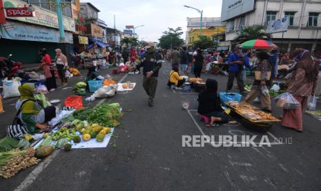 Anggota Satuan Polisi Pamong Praja Kota Salatiga memberi pengumuman waktu pasar pagi akan habis kepada pedagang di Pasar Pagi Salatiga, Jawa Tengah, Rabu (29/4). Pemerintah Kota Salatiga menata para pedagang pasar pagi dengan menerapkan physical distancing satu meter antarpedagang.