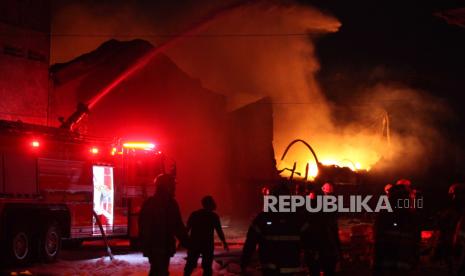 Petugas pemadam kebakaran memadamkan gudang tiner yang terbakar di Kalianak, Surabaya, Jawa Timur, Senin (18/12/2023). Sebanyak 30 kendaraan pemadam kebakaran dari Dinas Pemadam Kebakaran dan Penyelamatan (DPKP) Kota Surabaya dikerahkan untuk memadamkan kebakaran yang mengakibatkan enam orang pekerja di tempat itu mengalami luka bakar.