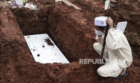  Seorang anak laki-laki berdoa di atas makam ayahnya yang meninggal karena Covid-19.Warga Kabupaten dan Kota Sukabumi, Jawa Barat yang meninggal dunia akibat tertular COVID-19 sudah menembus angka hingga 144 orang. 