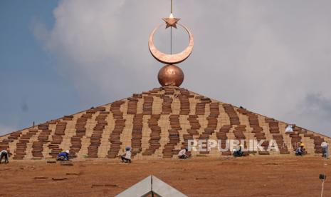 Sejumlah pekerja menyelesaikan pemasangan atap pada proyek pembangunan Masjid Agung Jawa Tengah (MAJT) Magelang, di Sawitan, Mungkid, Magelang, Jawa Tengah, Selasa (19/12/2023). Pembangunan masjid berkonsep Islamic Center seluas 4,9 hektare dengan anggaran pembangunan sebesar Rp120 miliar tersebut diharapkan menjadi destinasi wisata religi pelengkap Candi Borobudur.