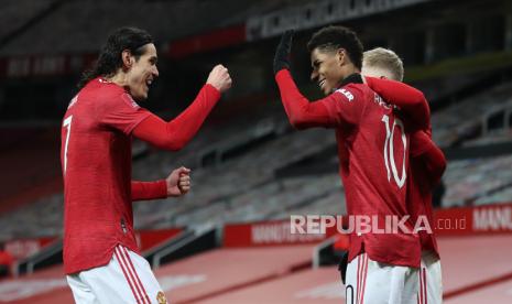 Marcus Rashford (tengah) dari Manchester United merayakan dengan rekan satu timnya setelah mencetak keunggulan 2-1 selama pertandingan sepak bola putaran keempat Piala FA Inggris antara Manchester United dan Liverpool di Manchester, Inggris, 24 Januari 2021.