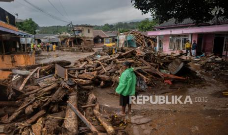 Warga mengamati proses evakuasi akibat banjir bandang di Kampung Cibuntu, Desa Pasawahan, Kecamatan Cicurug, Kabupaten Sukabumi, Jawa Barat, Selasa (22/9). Banjir bandang tersebut terjadi pada Senin (21/9) pukul 17.00 WIB akibat luapan sungai Citarik-Cipeuncit yang merendam tiga kecamatan yakni Cicurug, Parungkuda, Cidahu dan menyebabkan 234 rumah rusak, 210 kepala keluarga mengungsi serta tiga orang meninggal dunia. Republika/Thoudy Badai