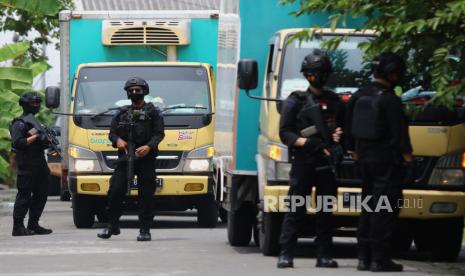 Personel Brimob berjaga di dekat truk yang mengangkut vaksin COVID-19 Sinovac di kantor Dinas Kesehatan (Dinkes) Provinsi Jawa Timur, Surabaya, Jawa Timur, Senin (4/1/2021). Sebanyak 77.760 dosis vaksin COVID-19 Sinovac tiba di kantor tersebut dan selanjutnya disimpan di ruang pendingin atau cold room. 