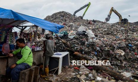 Pemulung beristirahat di dekat alat berat yang mengeruk sampah di Tempat Pembuangan Akhir (TPA) Jatiwaringin, Kabupaten Tangerang, Banten, Kamis (6/2/2025). 