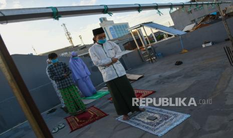 Umat Islam melaksanakan shalat Idul Fitri 1441 Hijriah di lantai atas indekos kawasan Pasar Baru, Jakarta Pusat, Minggu (24/5/2020). Shalat Idul Fitri 1441 Hijriah berjemaah yang dilakukan di rumah dengan jumlah yang terbatas tersebut sesuai imbauan pemerintah guna mencegah penyebaran COVID-19 dan memaksimalkan penerapan Pembatasan Sosial Berskala Besar (PSBB)