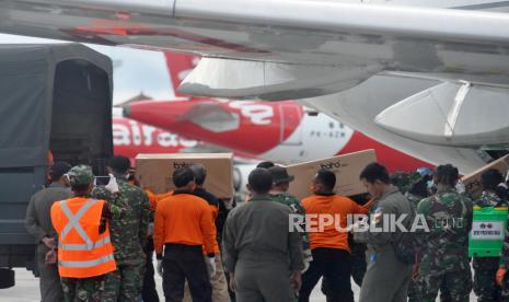 Petugas memindahkan Alat Pelindung Diri (APD) dari pesawat B737-400 milik TNI AU di Bandara I Gusti Ngurah Rai, Bali, Senin (23/3/2020). 