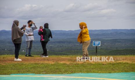 Sejumlah warga mengunjungi lokasi yang rencananya akan dibangun Istana Negara di Kawasan Ibu Kota Negara (IKN) Nusantara di Kecamatan Sepaku, Kabupaten Penajam Paser Utara, Kalimantan Timur, Ahad (6/2/2022). Dalam Pasal 6 UU IKN telah diatur mengenai cakupan wilayah IKN yang meliputi daratan seluas 256.142 hektare serta wilayah perairan laut dengan luas 68.189 hektare dan luas wilayah darat IKN Nusantara dari 56.180 hektare kawasan IKN Nusantara dan 199.962 kawasan pengembangan. 