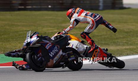 Marc Marquez dari Repsol Honda Team (kanan) mengalami kecelakaan dalam balapan MotoGP di Grand Prix Sepeda Motor Portugal di trek balap Algarve International, Portimao, Portugal, Ahad (26/3/2023).