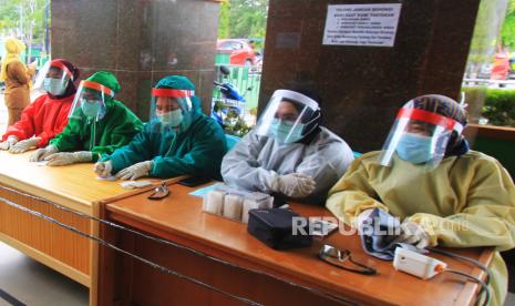 Tenaga medis menggunakan alat pelindung diiri saat melayani warga yang akan berobat di Pusat Kesehatan Masyarakat (Puskesmas) - ilustrasi