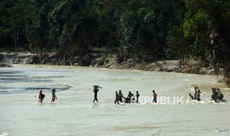 Pengungsi menyeberangi sungai di Desa Kamiri Masamba, kabupaten Luwu Utara, Sulawesi Selatan Selasa (21/07/2020). Warga di derah tersebut terpaksa menyeberangi sungai untuk mengambil bantuan karena jembatan penghubung desa mereka terputus akibat diterjang banding bandang. ANTARA FOTO/Yusran Uccang/hp.