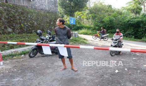 Sejumlah warga berada di jalan menuju lokasi penambangan pasir yang ditutup portal di kawasan lereng Gunung Merapi Desa Keningar, Dukun, Magelang, Jawa Tengah, Minggu (8/11/2020). BPPTKG (Balai Penyelidikan dan Pengembangan Teknologi Kebencanaan Geologi) merekomendasikan untuk menutup semua aktivitas penambangan pasir di Kawasan Rawan Bencana (KRB) III menyusul dinaikkannya status Gunung Merapi dari waspada level II menjadi siaga level III. 