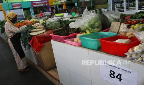 Pedagang menata sayuran saat Masa Transisi Normal Baru di pasar yang menerapkan sistem ganjil genap sebagai upaya mencegah penyebaran COVID-19 di Pasar Oro-oro Dowo, Malang, Jawa Timur, Selasa (9/6/2020). Forum Koordinasi Pimpinan Daerah jatim dan Malang Raya (Kota Batu, Kota Malang dan Kabupaten Malang) sepakat memperpanjang Masa Transisi Normal Baru hingga tanggal 13 Juni 2020 karena angka penularan COVID-19 yang masih tergolong tinggi dengan jumlah pasien positif mencapai 210 orang hingga Senin (8/6)