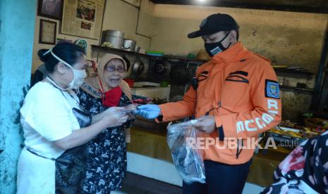 Petugas Damkar membagikan masker saat Sosialisasi Adaptasi Kebiasaan Baru (AKB) di Pasar Cihapit bersama dengan Badan Penanggulangan Bencana Daerah (BPBD) Provinsi Jawa Barat dan Damkar Kota Bandung, Rabu (5/8). Sesuai Peraturan Wali Kota (Perwal) No 43 Tahun 2020, dikenakan sanksi bagi yang melanggar berupa denda minimal Rp 100.000 dan maksimal Rp 500.000. Meski demikian saat ini masih diberlakukan sanksi sosial guna memberikan efek jera kepada pelanggar.