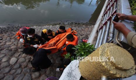 Petugas gabungan mengevakuasi jenazah anak yang tenggelam di Sungai Kalimas, Surabaya, Jawa Timur, Rabu (20/10/2021). Petugas dari Tim Rescue Dinas Pemadam Kebakaran Kota Surabaya bersama instansi terkait dan warga mengevakuasi anak tenggelam yang diduga terpeleset saat bermain bersama empat temannya di pinggiran sungai itu.