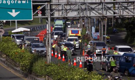 Petugas gabungan Satgas COVID-19 melakukan pemeriksaan surat keterangan tes cepat antigen kepada wisatawan di jalur wisata Puncak, Gadog, Kabupaten Bogor,   Jawa Barat, Jumat (12/2/2021).  Pemerintah Kabupaten Bogor mewajibkan wisatawan menunjukkan surat hasil tes cepat antigen bagi wisatawan yang hendak berwisata ke kawasan Puncak Bogor  sebagai upaya meminimalisir penyebaran COVID-19 pada libur Tahun Baru Imlek 2572 dan libur akhir pekan. 