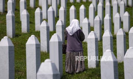 Seorang wanita berjalan berdiri di antara kuburan korban pembantaian Srebrenica, di pemakaman peringatan di Potocari, dekat Srebrenica, Bosnia timur, Selasa, 8 Juni 2021.