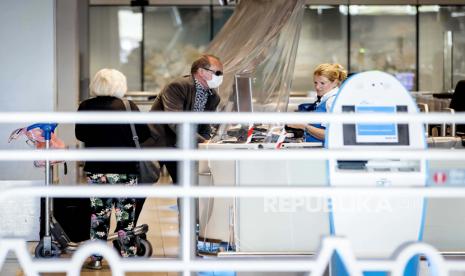 Wisatawan mengenakan masker di Bandara Schiphol, di Schiphol, Belanda, 19 Juli 2020. WHO mengingatkan agar anak muda tak lengah melakukan langkah pencegahan Covid-19.