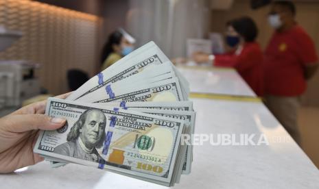 Karyawan menunjukkan uang dolar Amerika Serikat (AS) di tempat penukaran valuta asing, Jakarta, Rabu (6/1). Dolar AS melonjak ke level tertinggi dalam lebih dari 10 bulan pada akhir perdagangan Selasa (28/9), mengikuti kenaikan imbal hasil obligasi pemerintah AS.