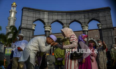 Sejumlah umat Muslim bersalaman usai melaksanakan shalat Idul Fitri 1442 Hijriah di Masjid Dian Al-Mahri, Depok, Jawa Barat Kamis (13/5). Masjid Dian Al-Mahri atau Masjid Kubah Emas Depok menyelenggarakan Shalat Idul Fitri 1442 Hijriah dengan kuota kapasitas jamaah sebanyak 50 persen dan protokol kesehatan yang ketat pada masa pandemi Covid-19. Republika/Putra M. Akbar