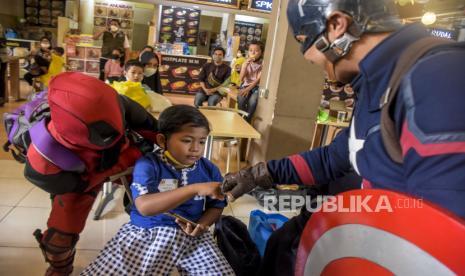 Anak bersama orang berpakaian superhero (ilustrasi). Terkadang, anak lelaki memiliki obsesi untuk memiliki tubuh seperti superhero.