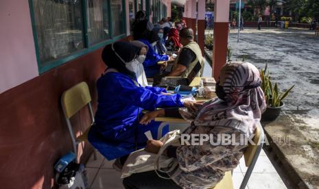 Sejumlah warga menjalani pemeriksaan kesehatan sebelum disuntik vaksin Covid-19 di SDN 053 Cisitu, Jalan Sangkuriang, Kota Bandung, Senin (9/8). Pemerintah Provinsi Jawa Barat menargetkan 37 juta masyarakat telat mendapatkan penyuntikan vaksin Covid-19 pada Desember 2021 dengan target harian sebanyak 500 ribu dosis per harinya. 